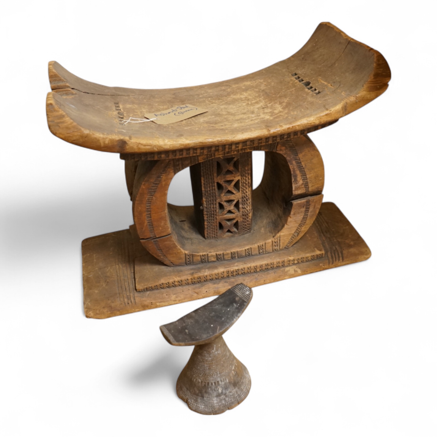 An Ashanti carved wood stool together with a similar headrest, tallest 41cm